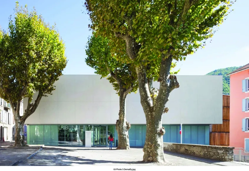 sur la place des récollets, la transparence du hall d’entrée invite à entrer, tandis qu’à l’étage, le volume en en béton brut blanc protège la salle d’audience pénale de l’environ- nement extérieur.