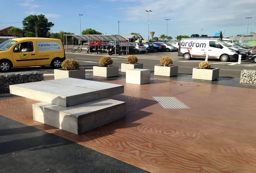 Leparvisdel'hypermarchéLeclerc fait l'objet d'un traitement résolument contemporain, avec du mobilier urbain en béton et une palette de trois couleurs : noir, gris et brun-rouge.