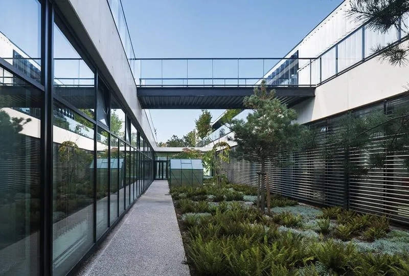 Les ateliers s’ouvrent sur les patios plantés de la douve. Les ateliers s’ouvrent sur les patios plantés de la douve.