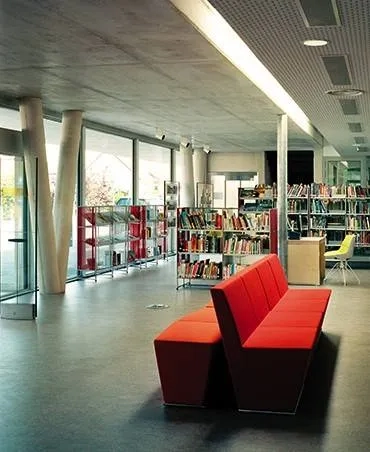 Hall d’entrée où s’avance la salle de lecture. le plafond béton, correspond à la partie du bâtiment de deux niveaux. une faille vitrée marque la transition avec la partie de plain-pied. Hall d’entrée où s’avance la salle de lecture. le plafond béton, correspond à la partie du bâtiment de deux niveaux. une faille vitrée marque la transition avec la partie de plain-pied.